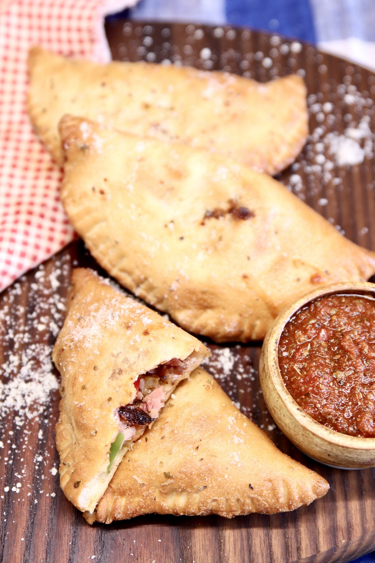 calzones and pizza sauce, one cut in half
