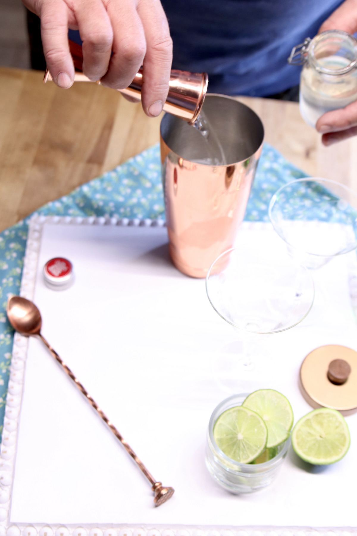 adding simple syrup to a cocktail shaker for gimlet