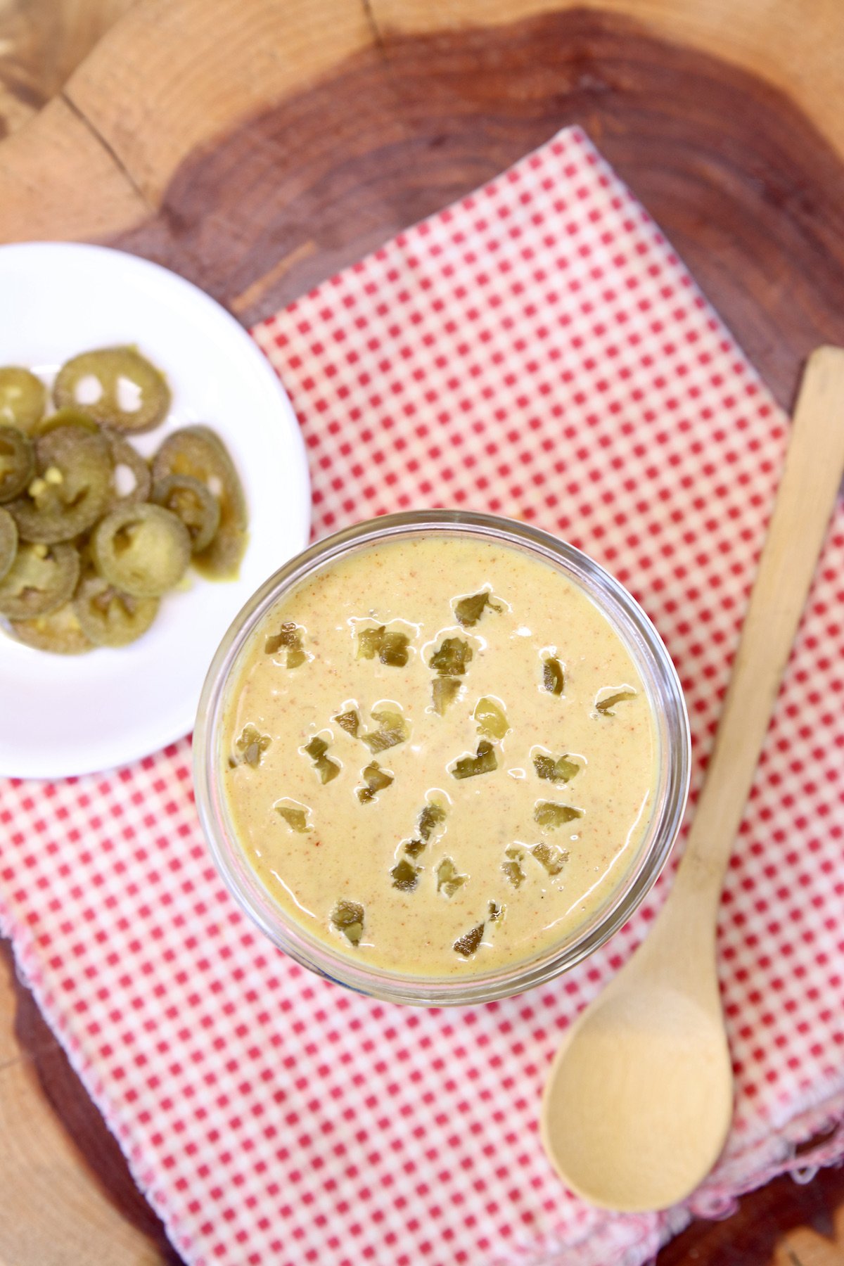 overhead of jar of spicy honey mustard, small bowl of sliced jalapenos