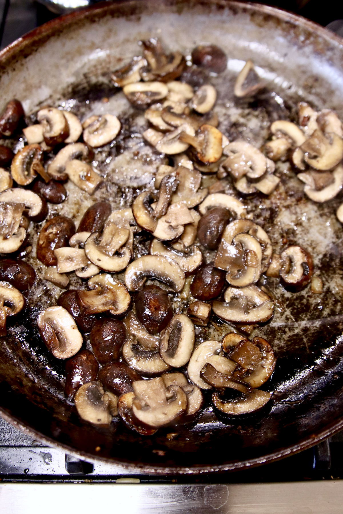 cooking sliced mushrooms in a skillet