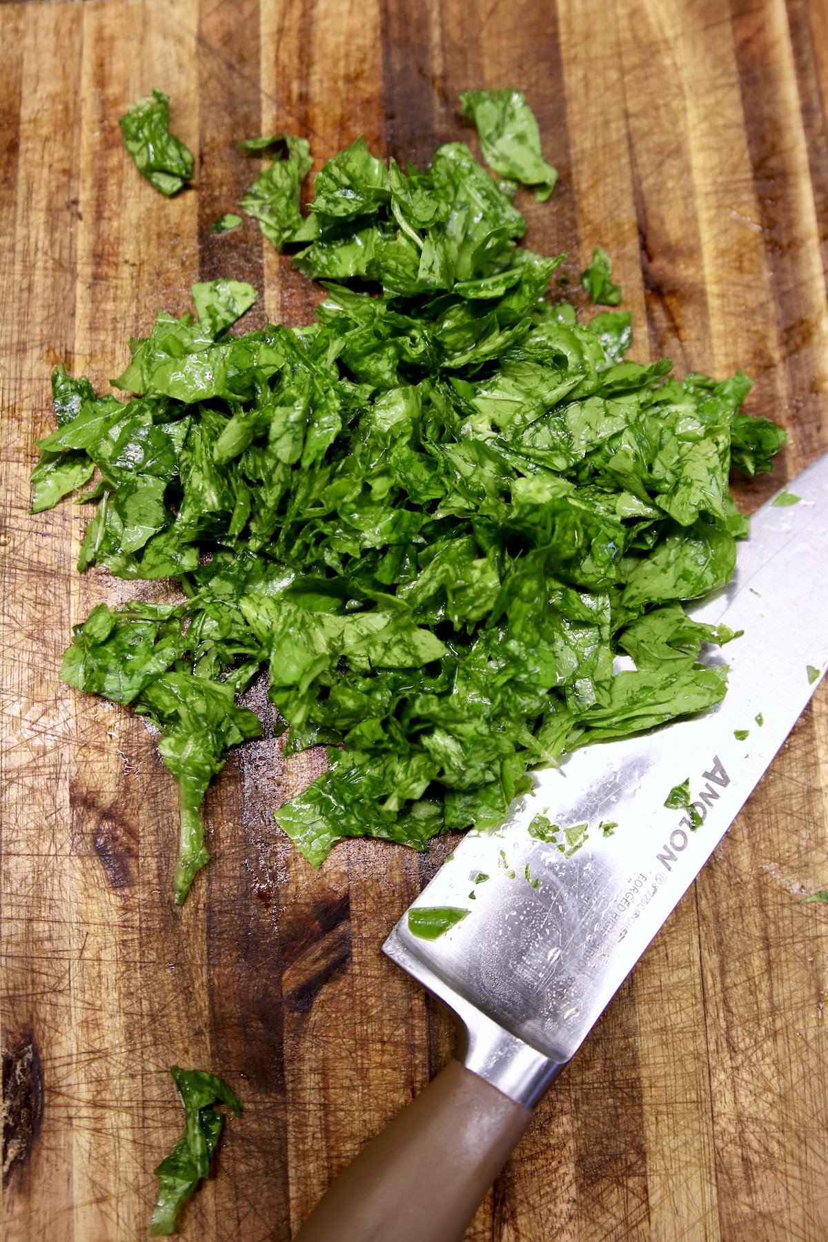 chopped turnip greens on a cutting board with knife
