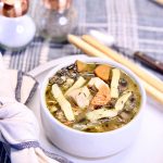 bowl of chicken noodle soup on a plate.