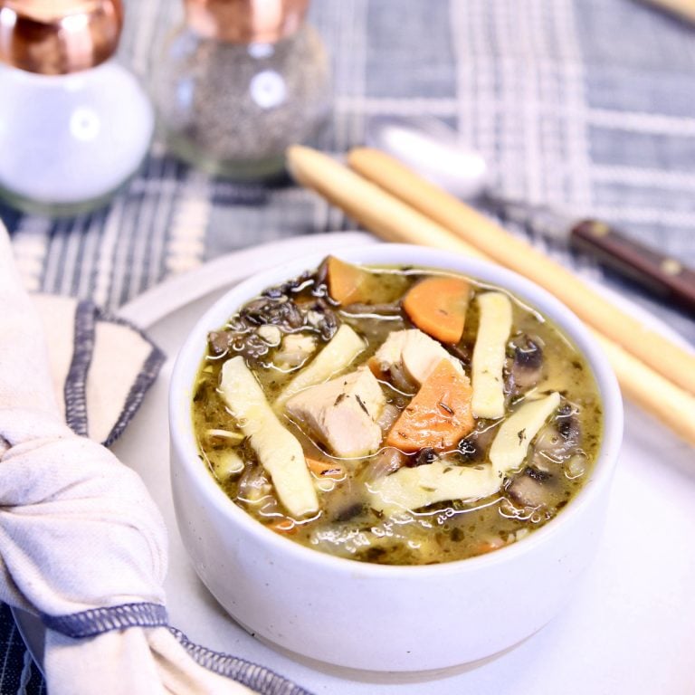 bowl of chicken noodle soup on a plate.