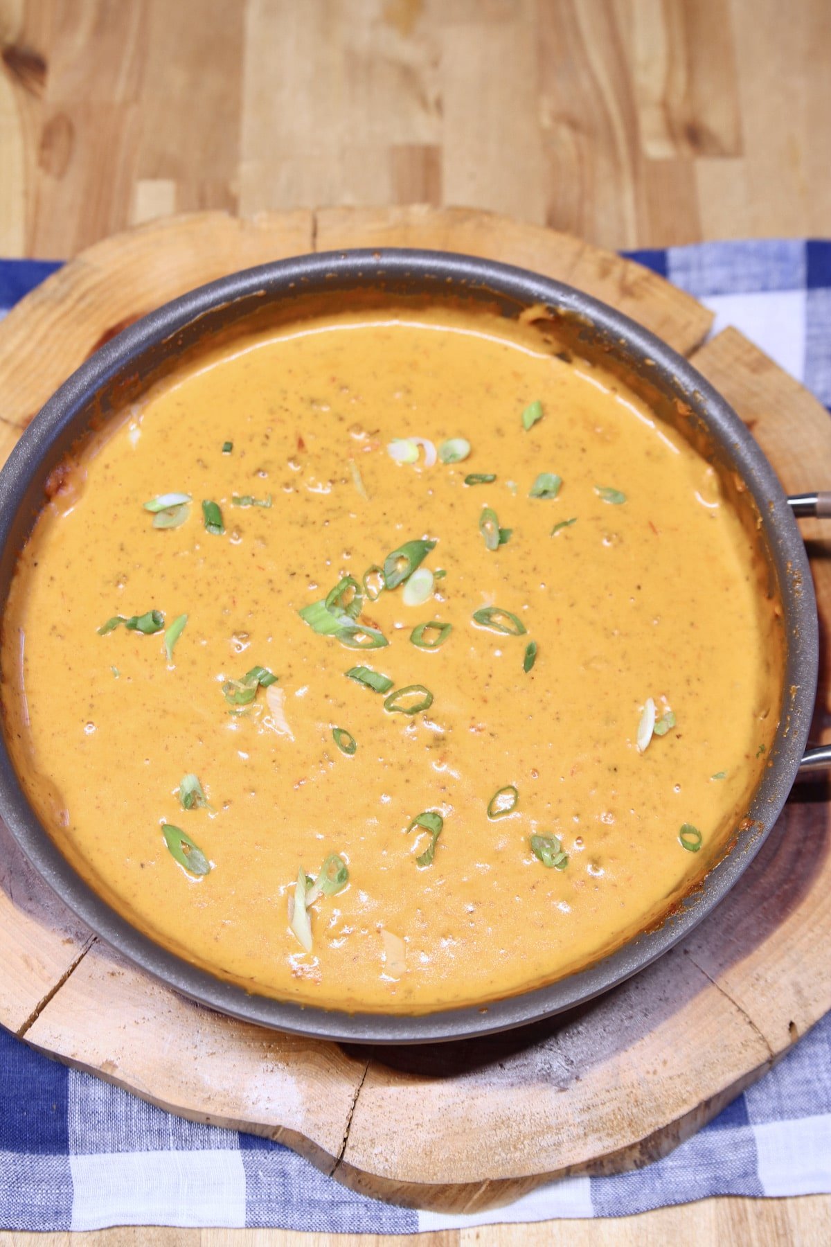 Chili Cheese Dip garnished with Green Onions in a pan.