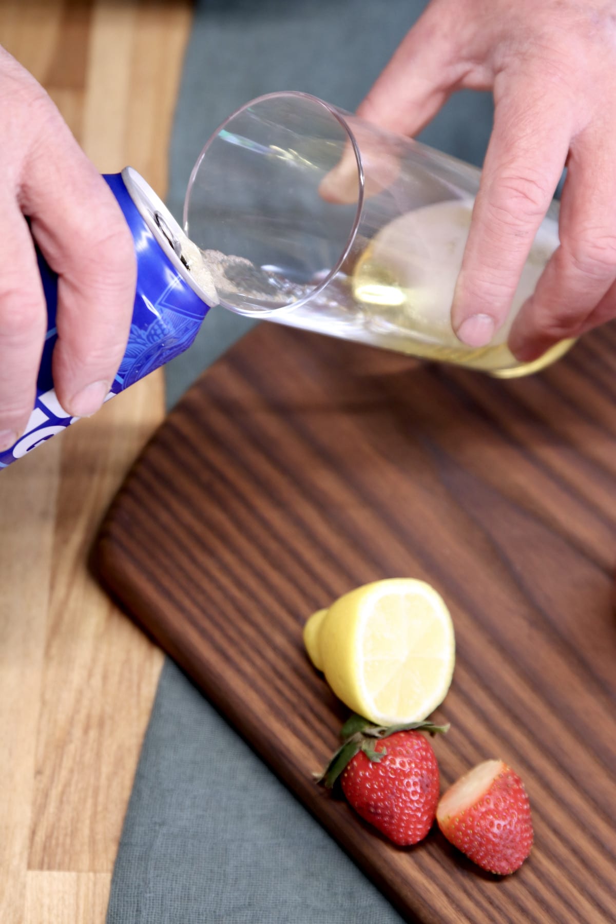 filling a glass with can of beer.