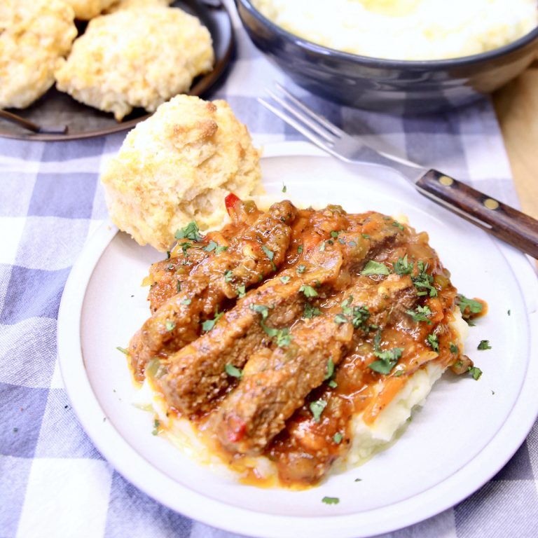 plate of Swiss steak over mashed potatoes