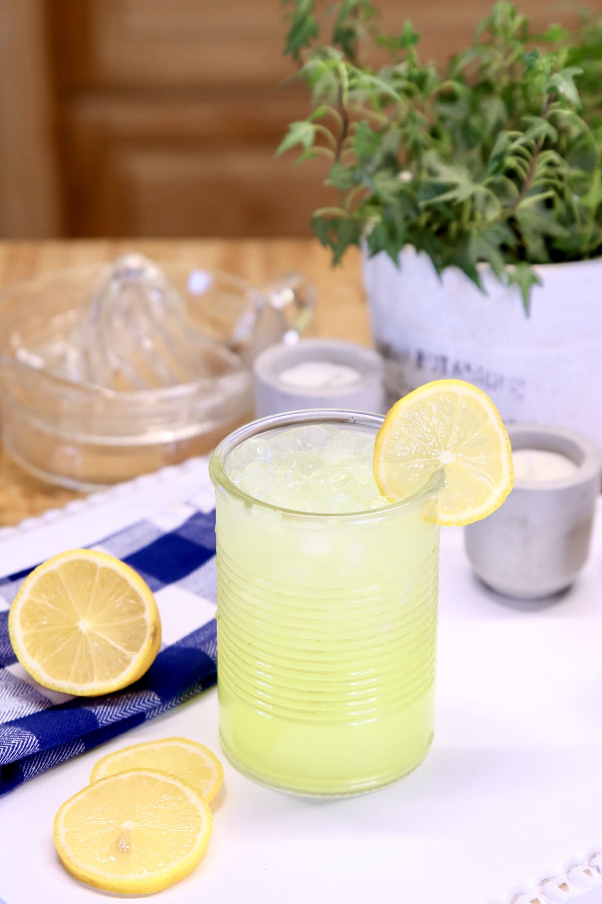 lemonade in a glass with ivy plant in background.