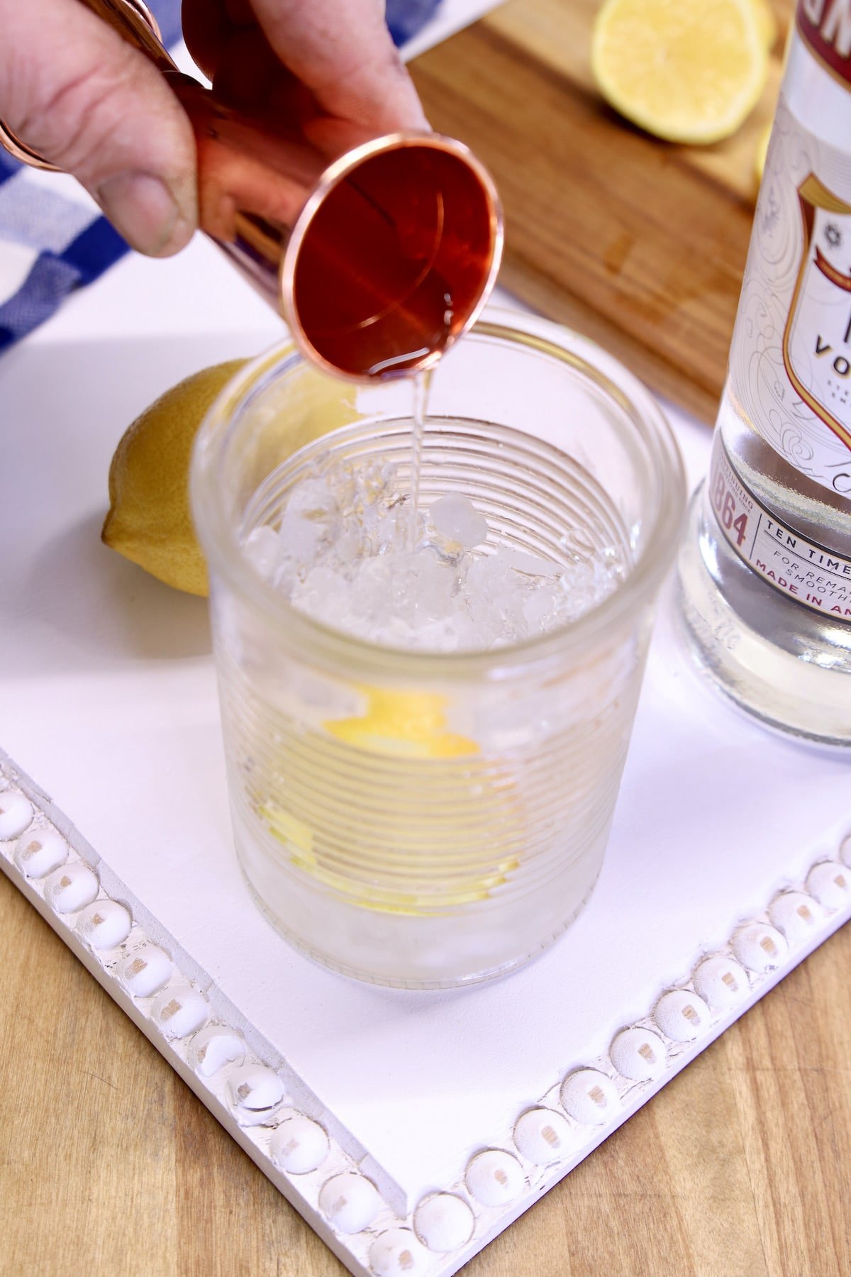 Pouring vodka into a glass with ice.