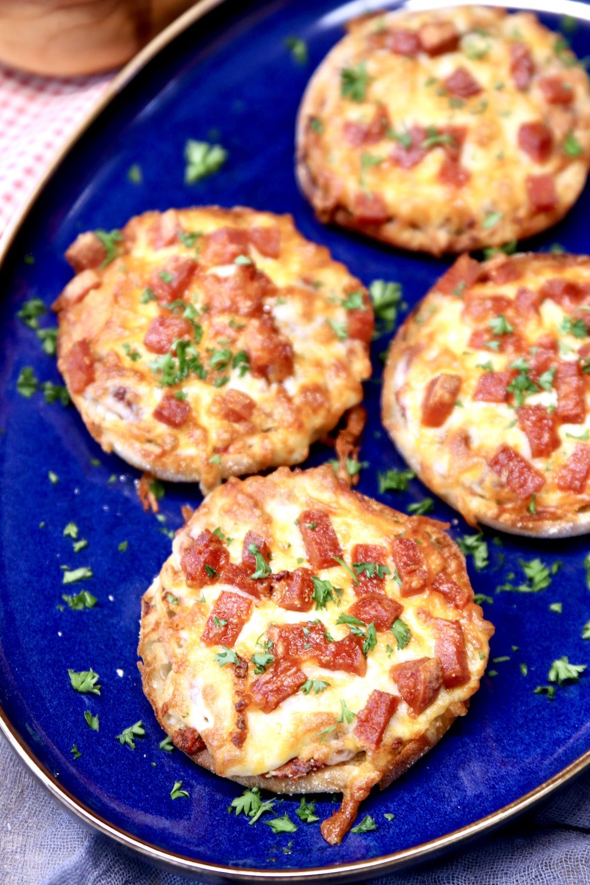Mini pepperoni pizzas on a blue platter.
