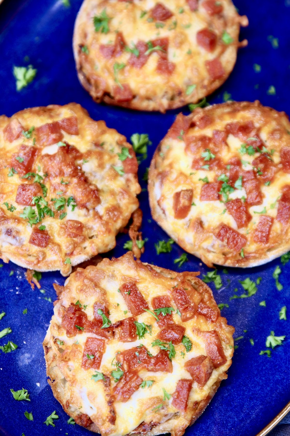 Closeup of 4 mini pepperoni pizzas.