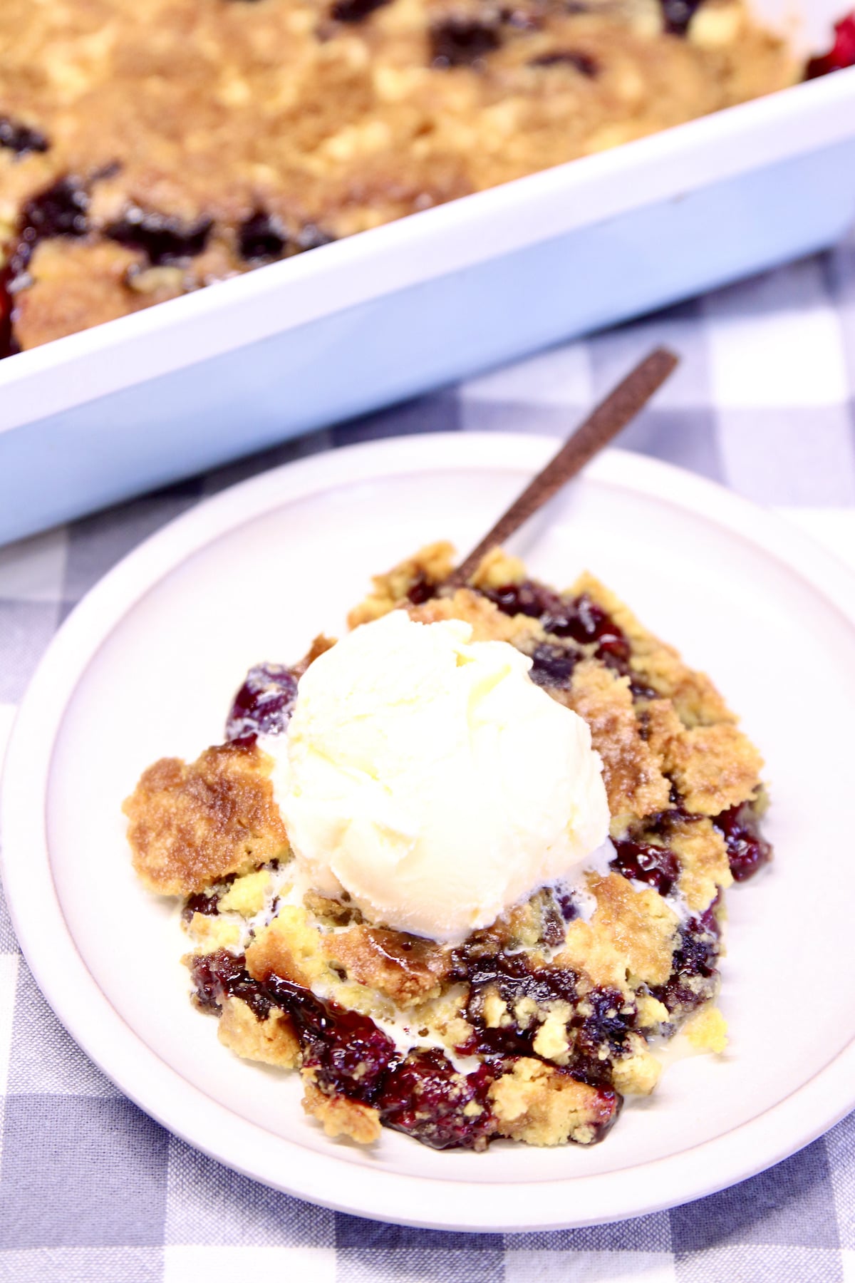 Plate of blackberry dump cake with ice cream.