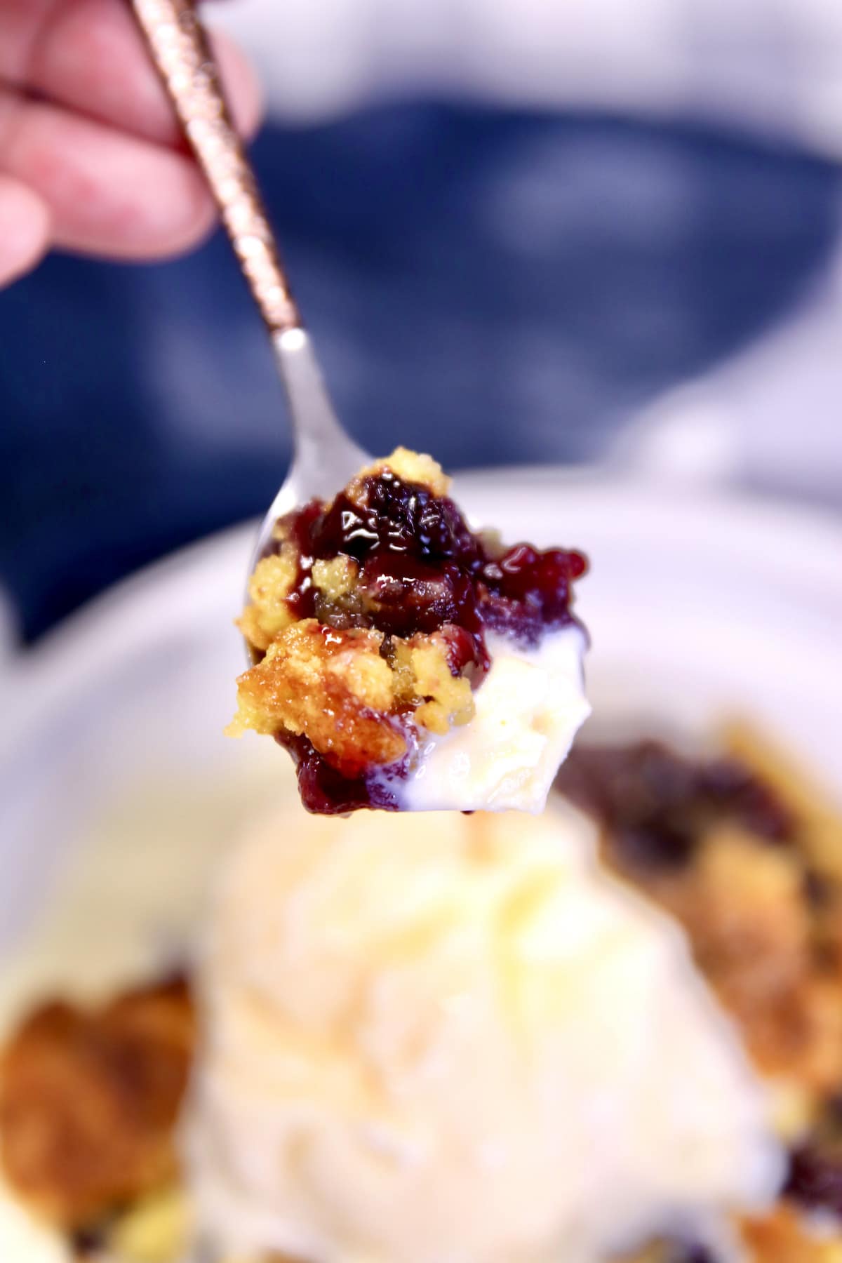 Bite of blackberry dump cake on a spoon.