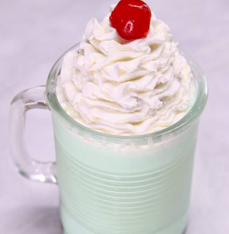 Boozy Shamrock Shake with whipped cream and cherry.