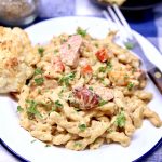 plate of pasta with creamy sauce and smoked sausage.