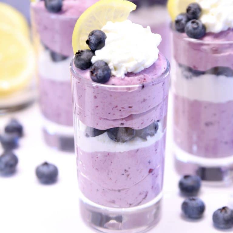 dessert glass with layered blueberry cheesecake.