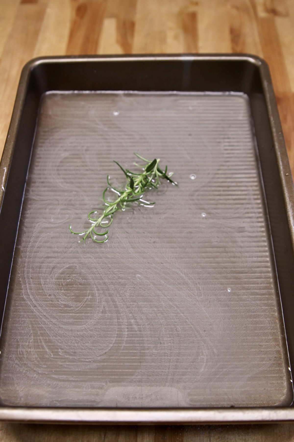 pan of sugar water and rosemary sprig.