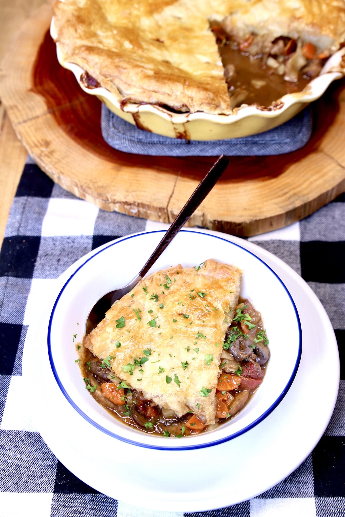 Bowl of steak pot pie, pie plate in background.