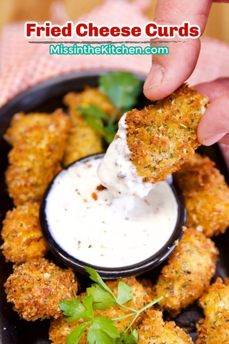 Fried cheese curds dipping in sauce. Text overlay.