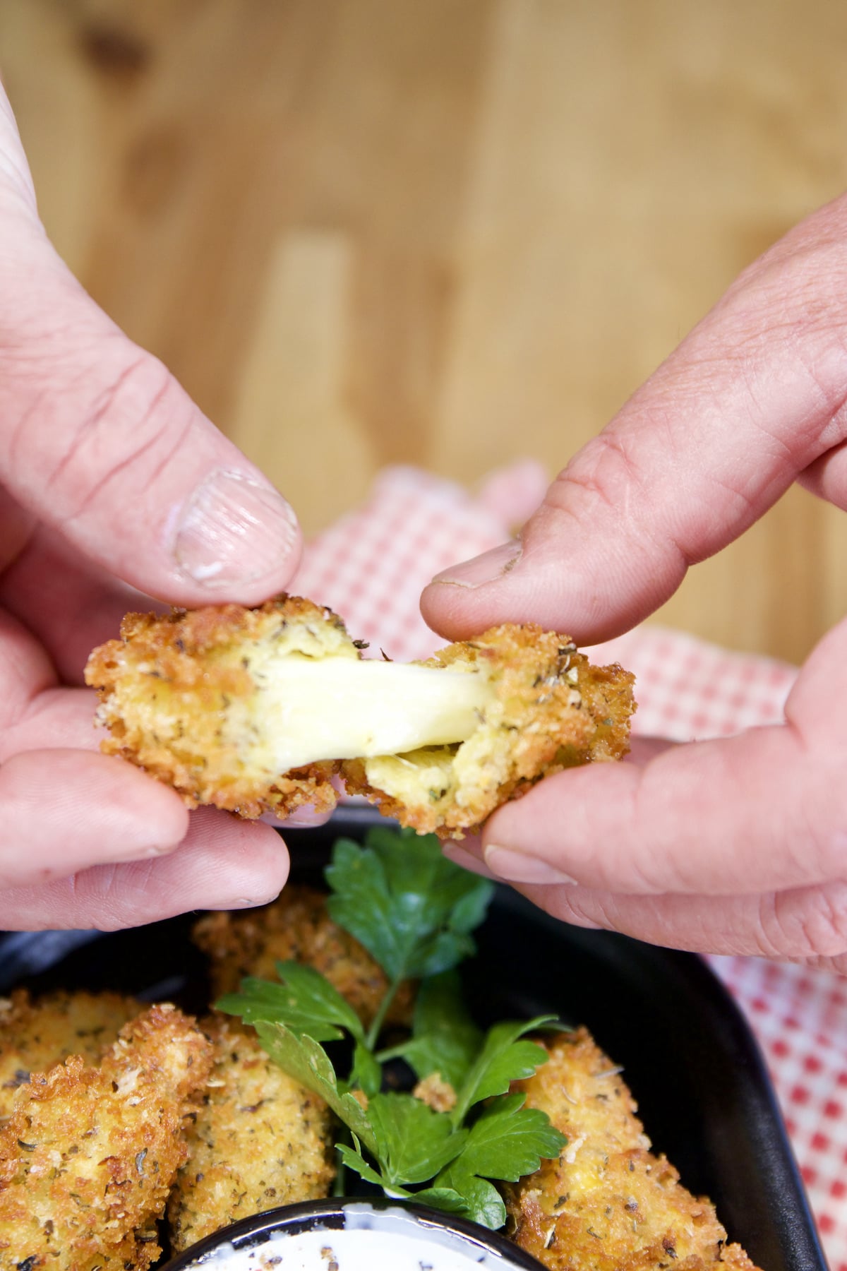 Pulling a fried cheese curd apart.