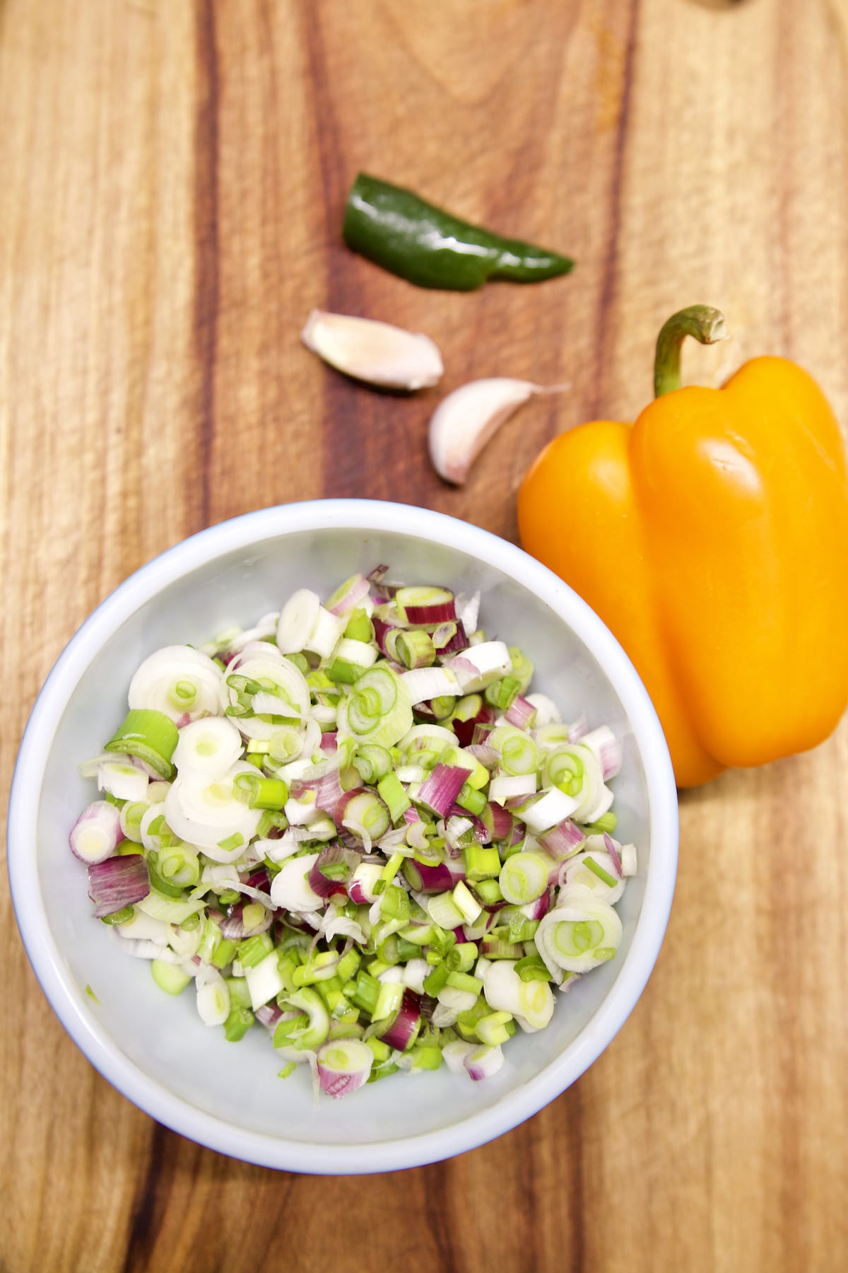 bowl of sliced onions, half yellow bell pepper, 2 garlic cloves, half jalapeno.
