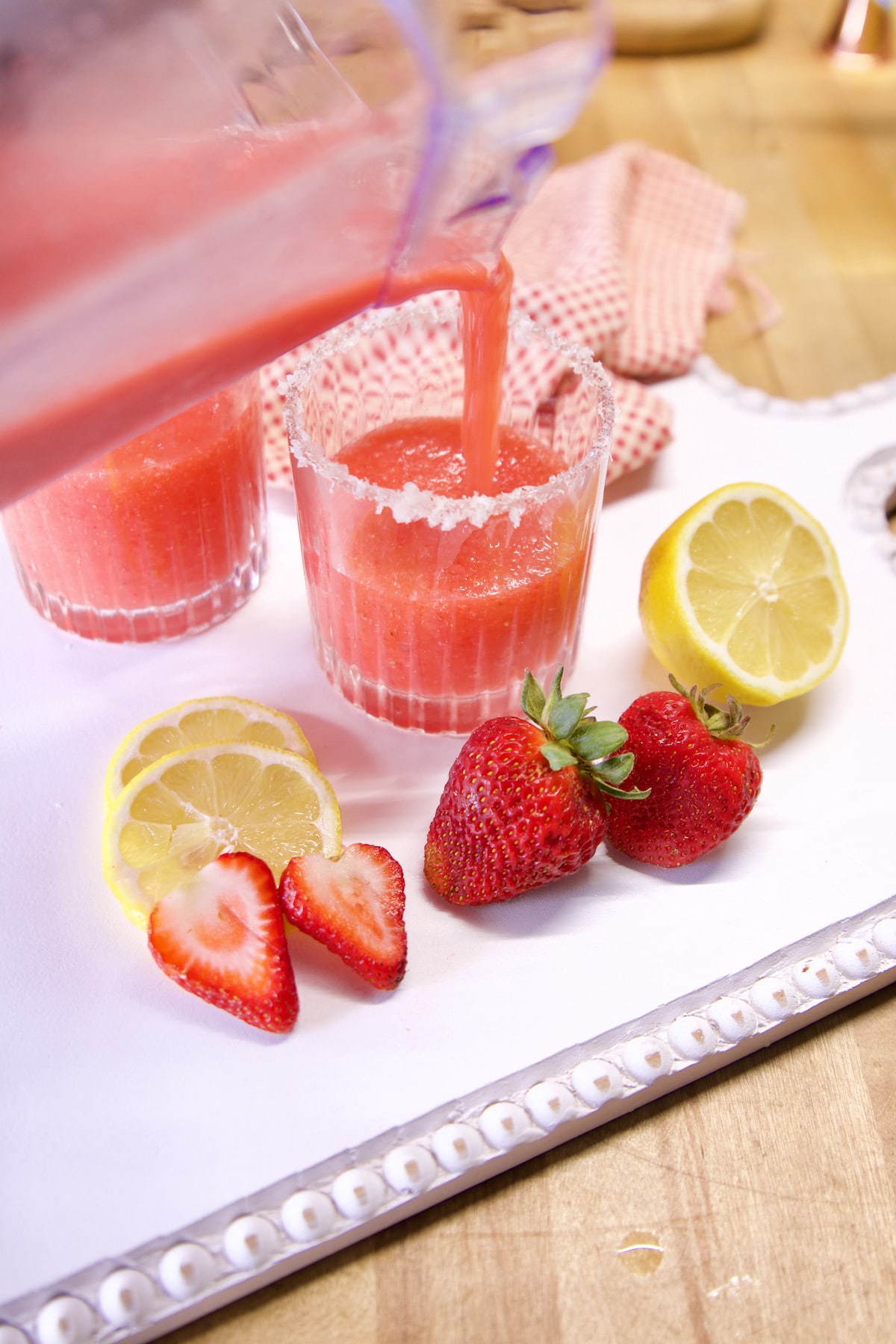 Filling glasses with strawberry margaritas.