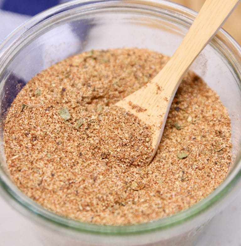 Creole seasoning in a bowl with wood spoon.
