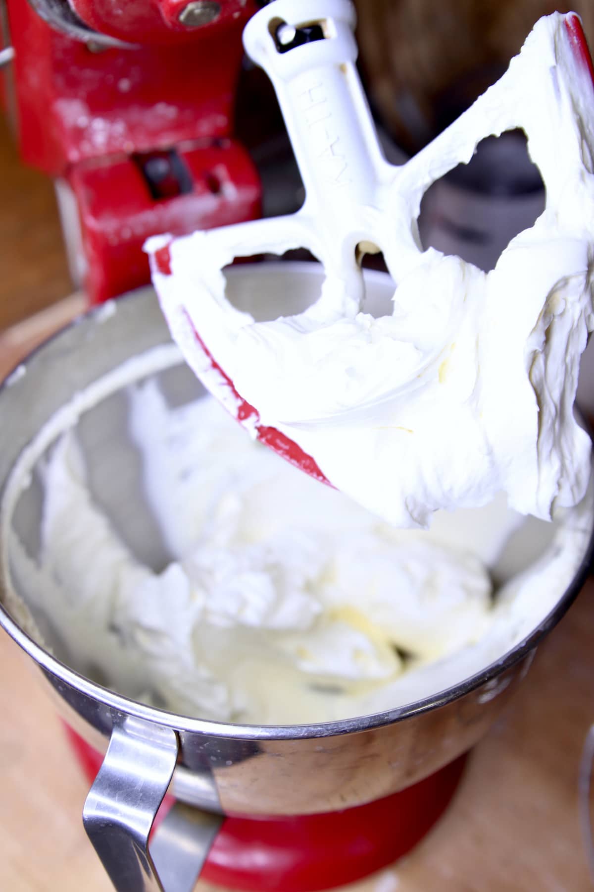 Mixer bowl and beater with creamed butter and cream cheese.