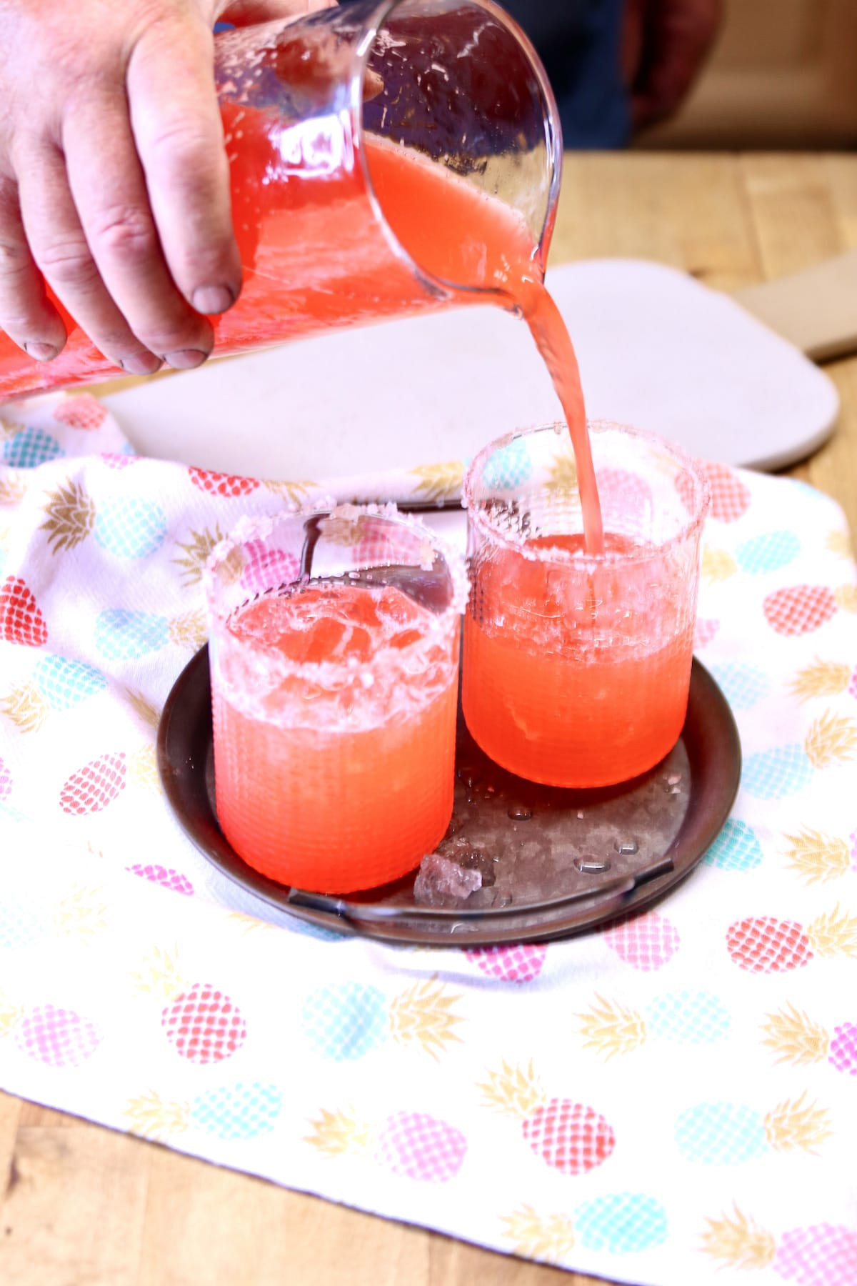 Pouring punch into glasses.