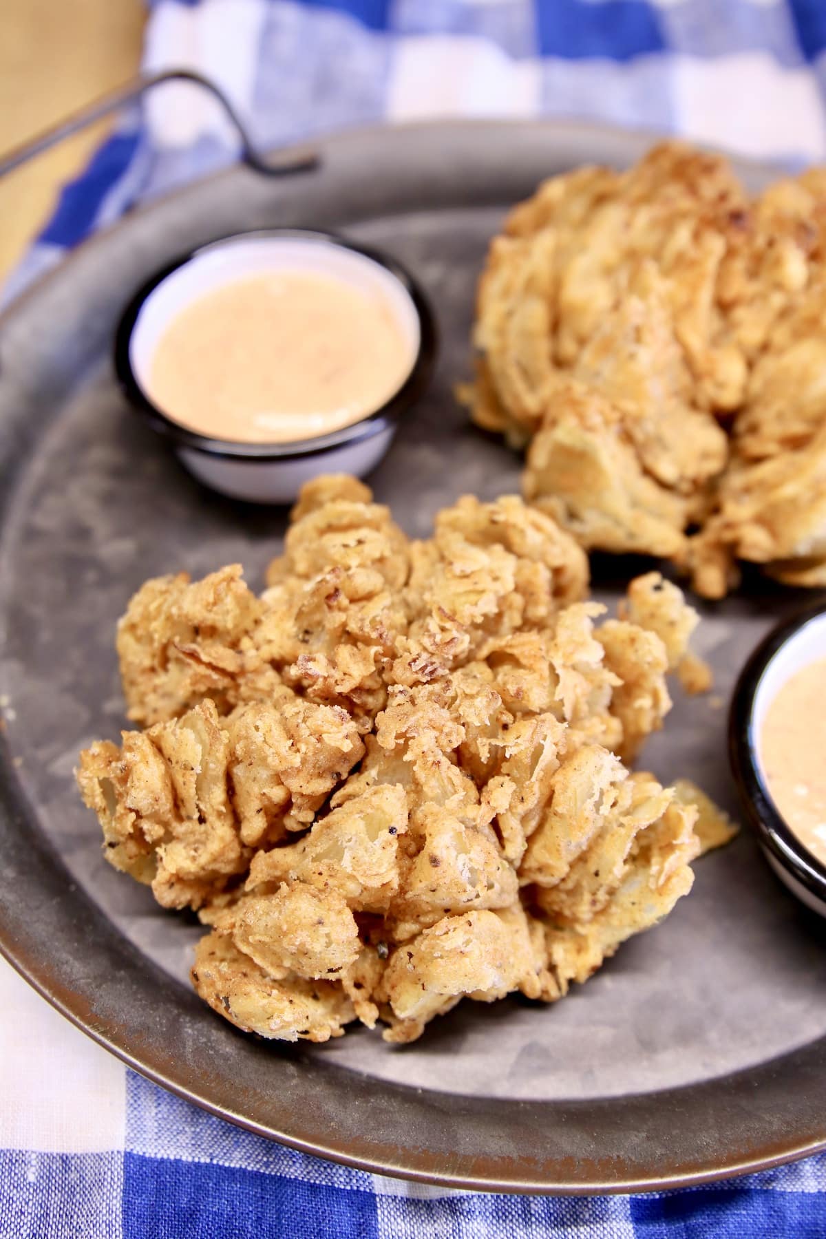 2 Blooming Onion appetizers with sauce cups.