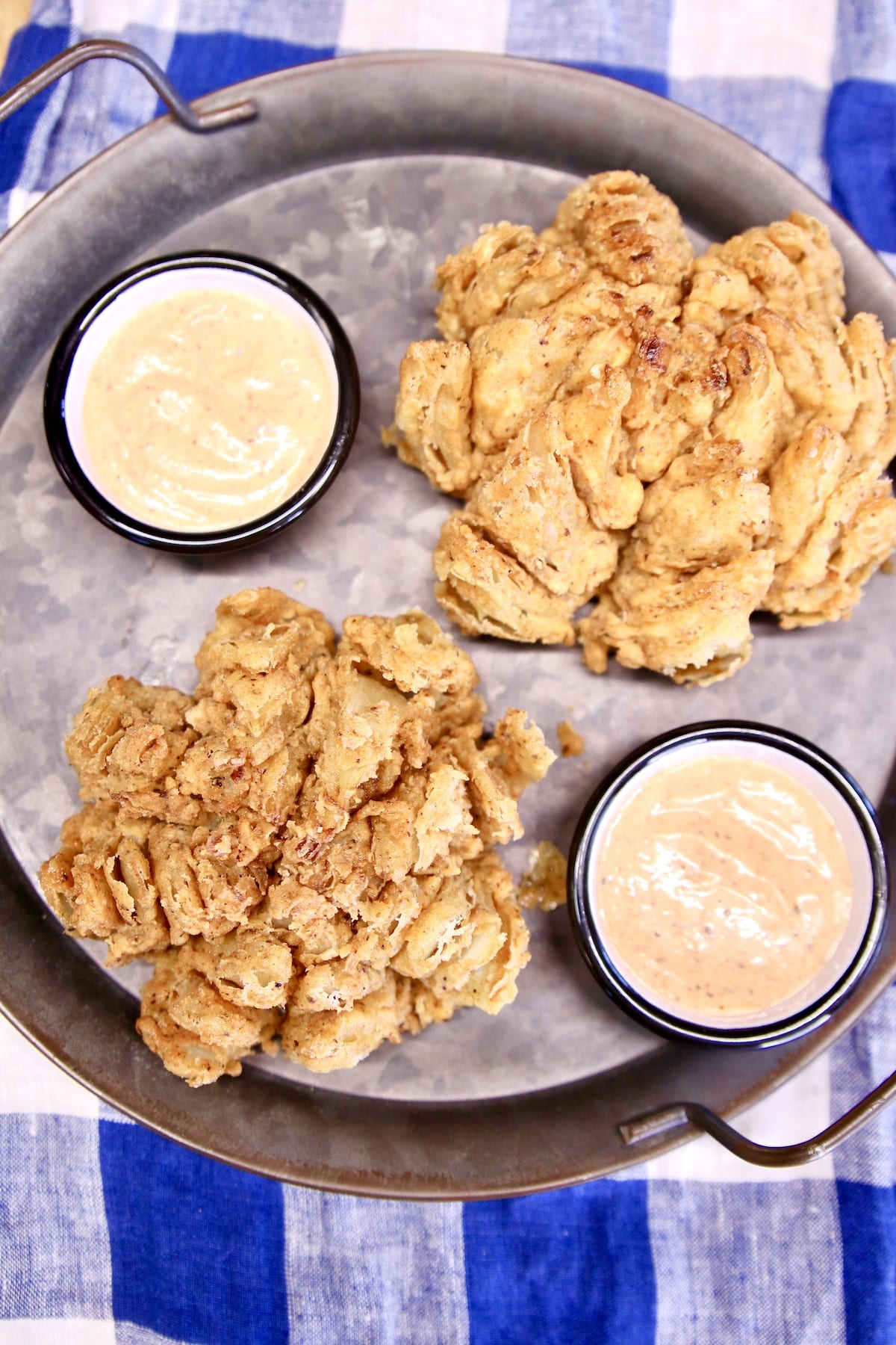 Overhead view of platter with 2 blooming onions and sauce cups.