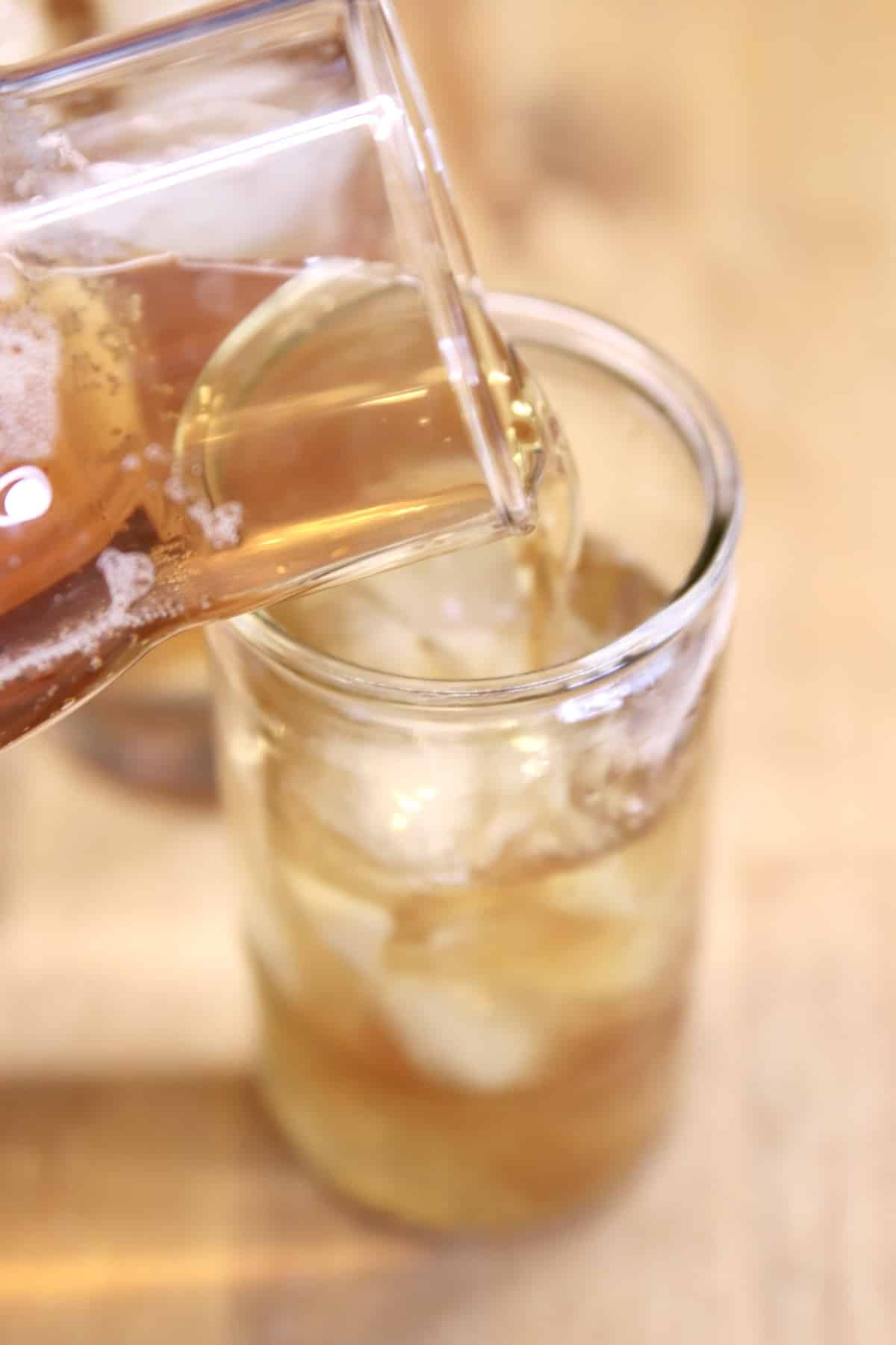 Pouring tea into a glass.