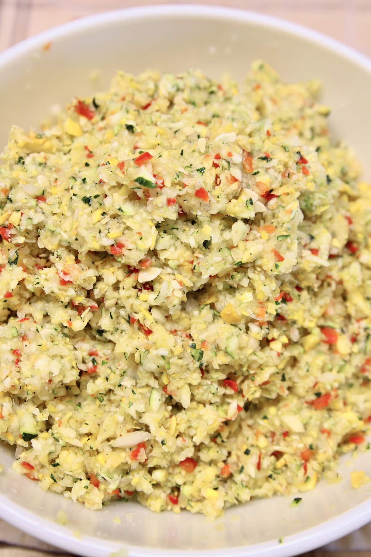 Bowl with finely chopped squash, peppers and onions.