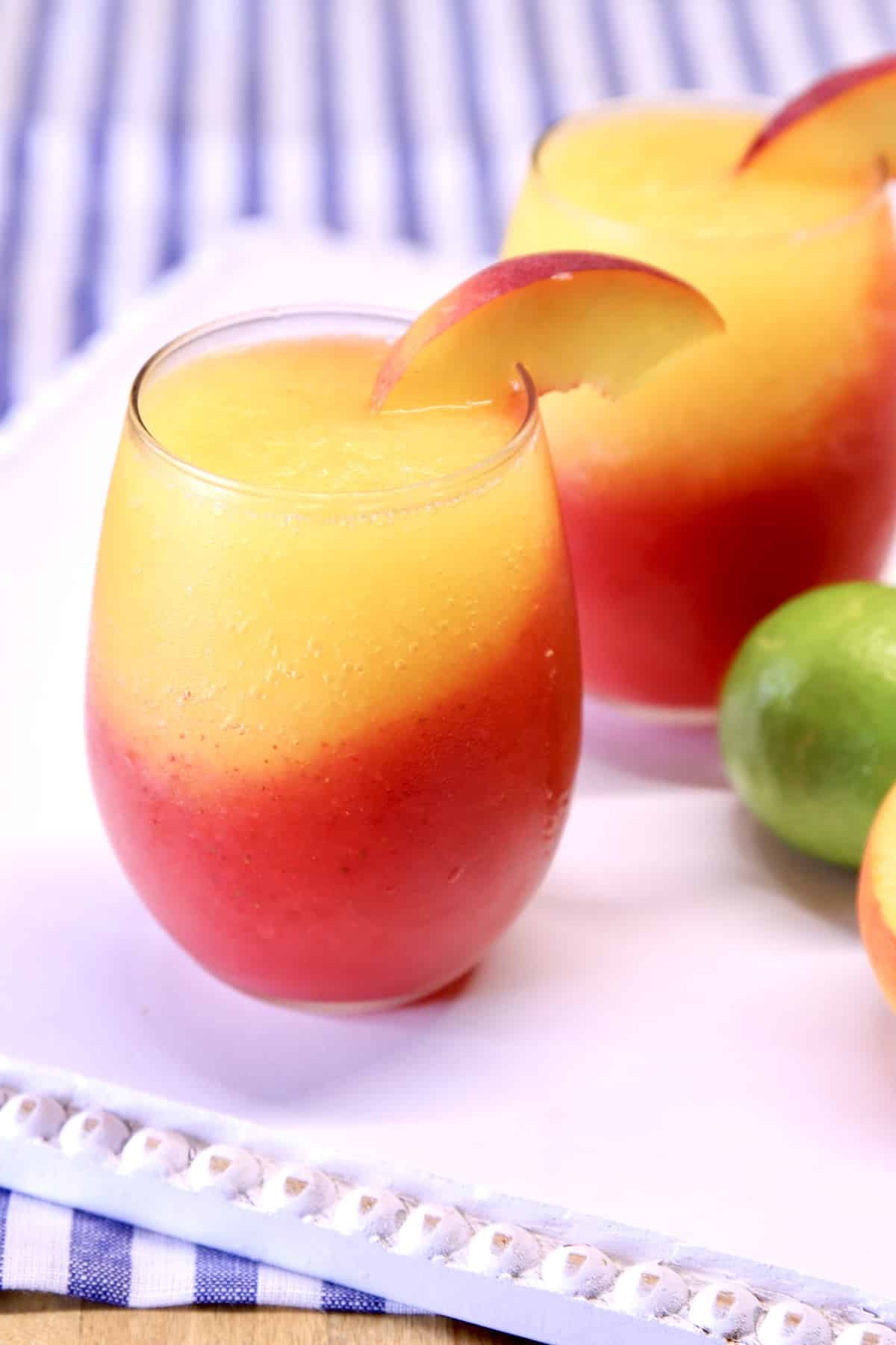 2 daiquiri cocktails, layers of peach and strawberry.
