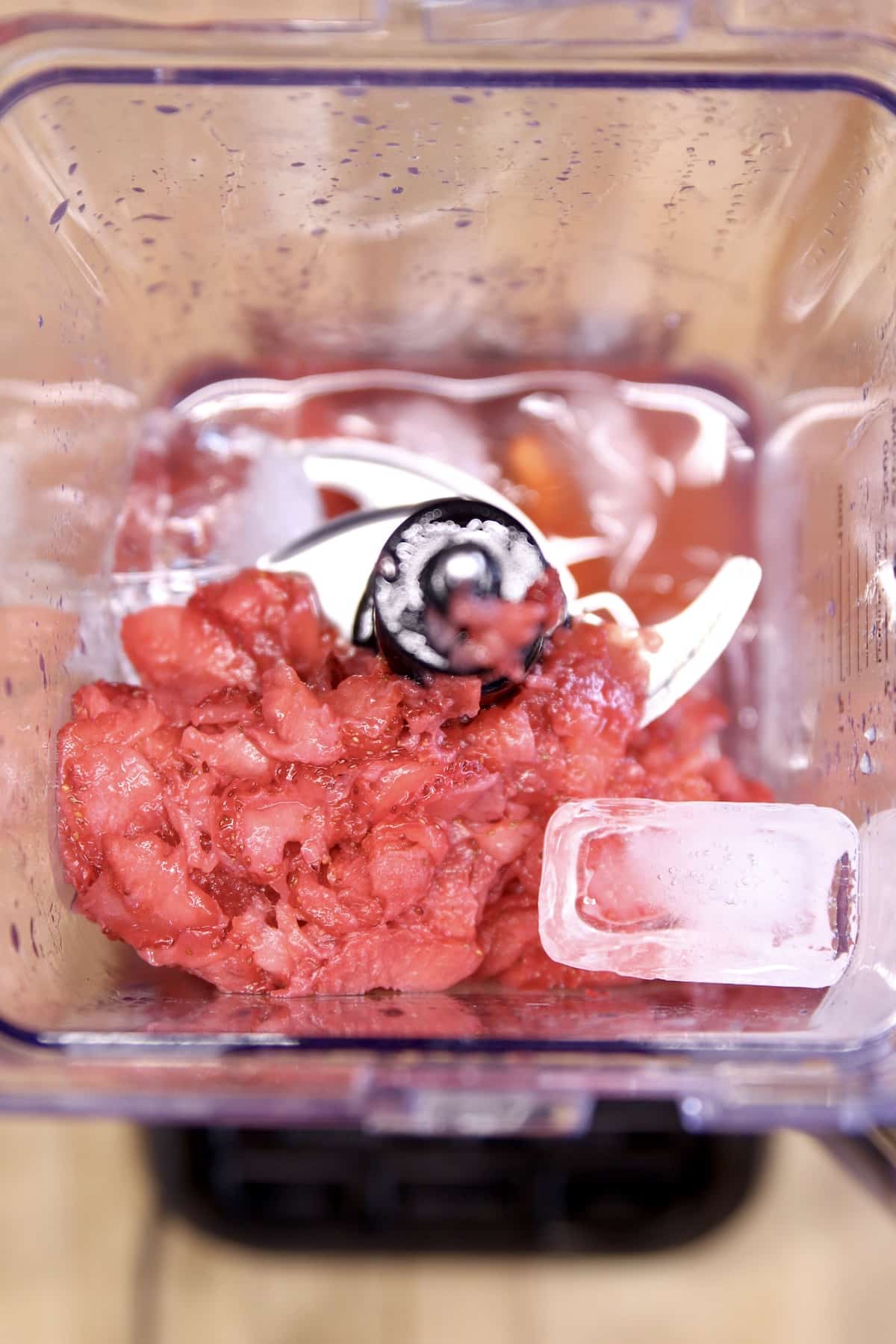 Blender with frozen strawberries, ice, rum.