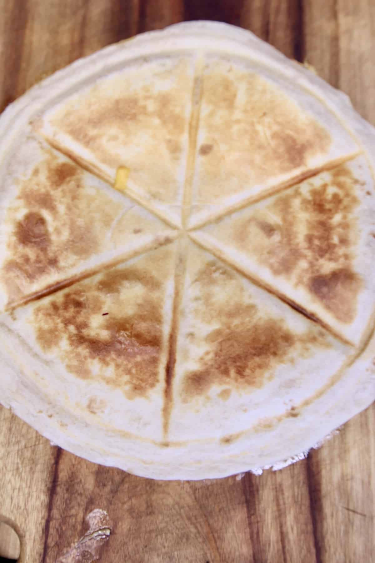 Sliced quesadilla on a cutting board.