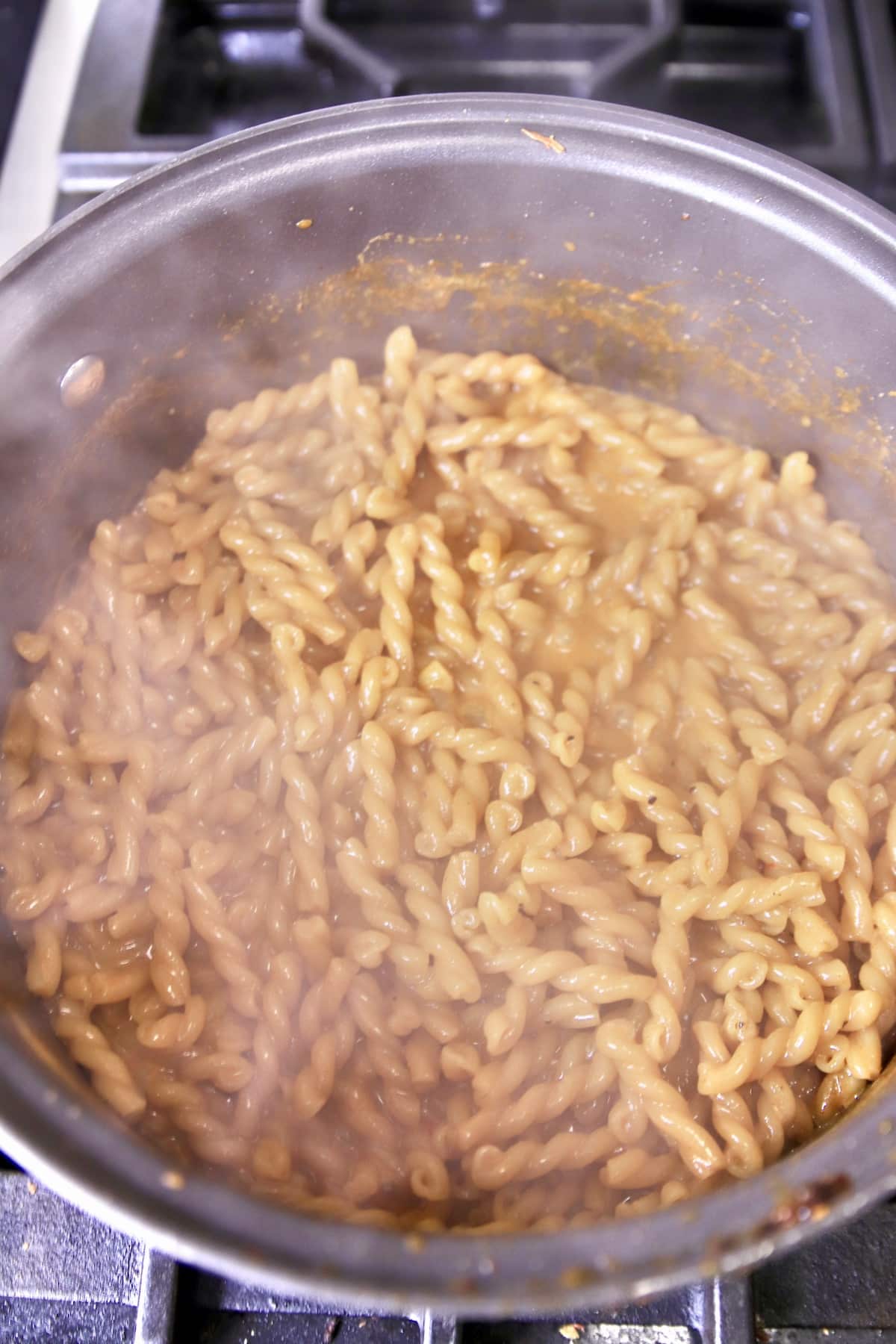 Cooking pasta in broth and cream.