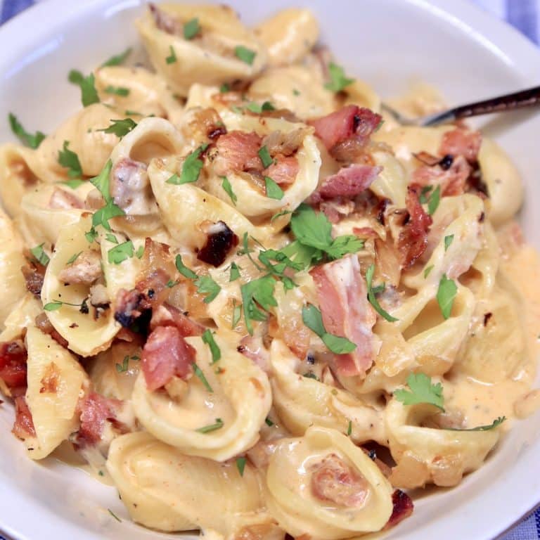 Pasta shells with cheese sauce and ham.