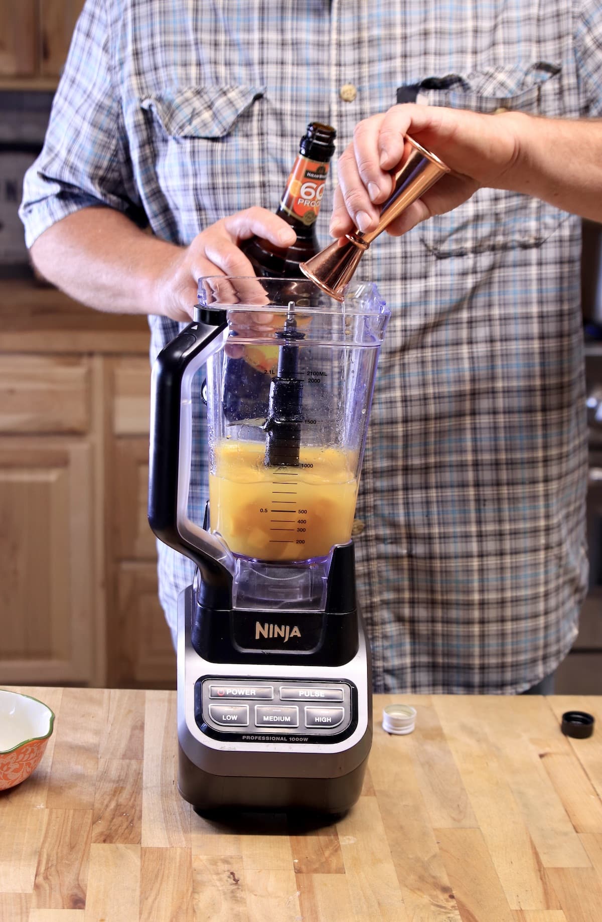 Adding triple sec to a blender.