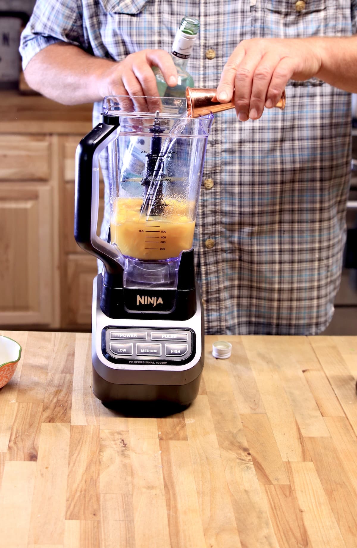 Adding rum to a blender.