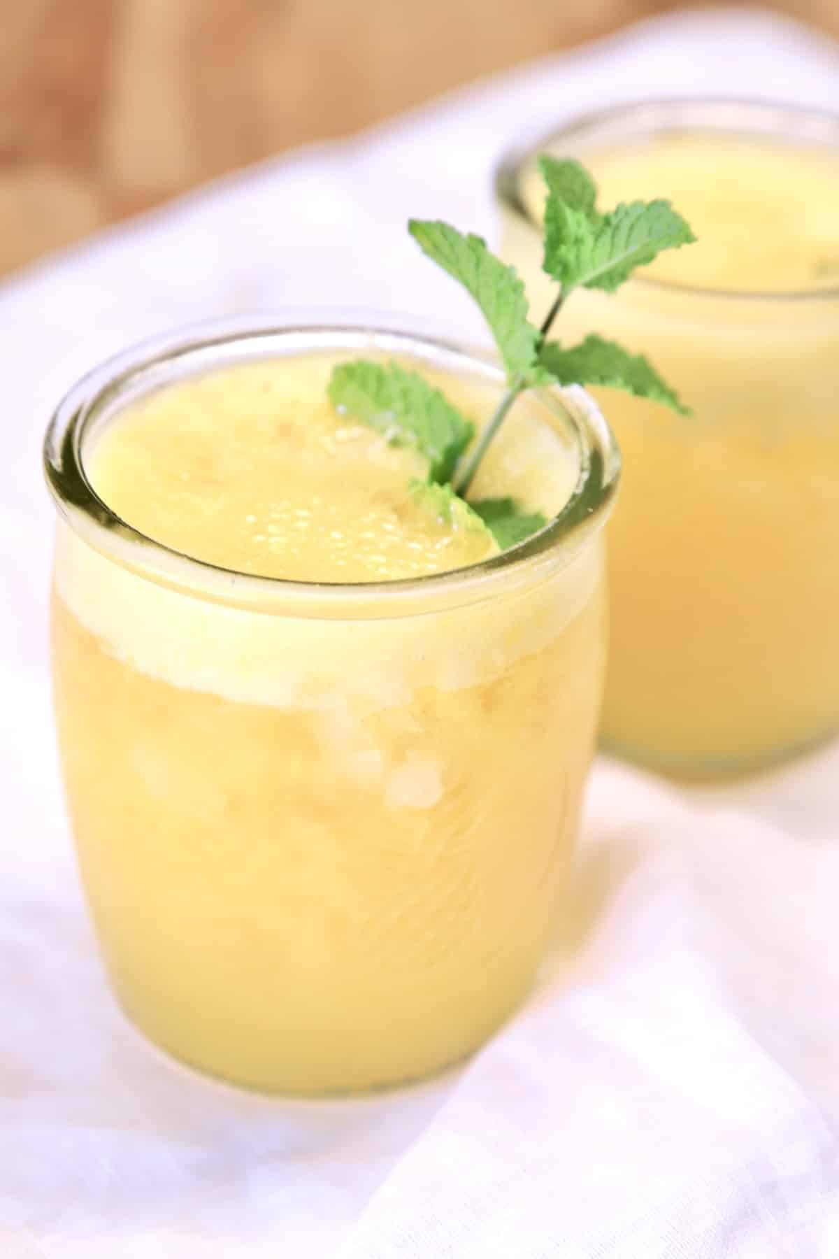 Rum cocktail in 2 glasses, mint garnish.