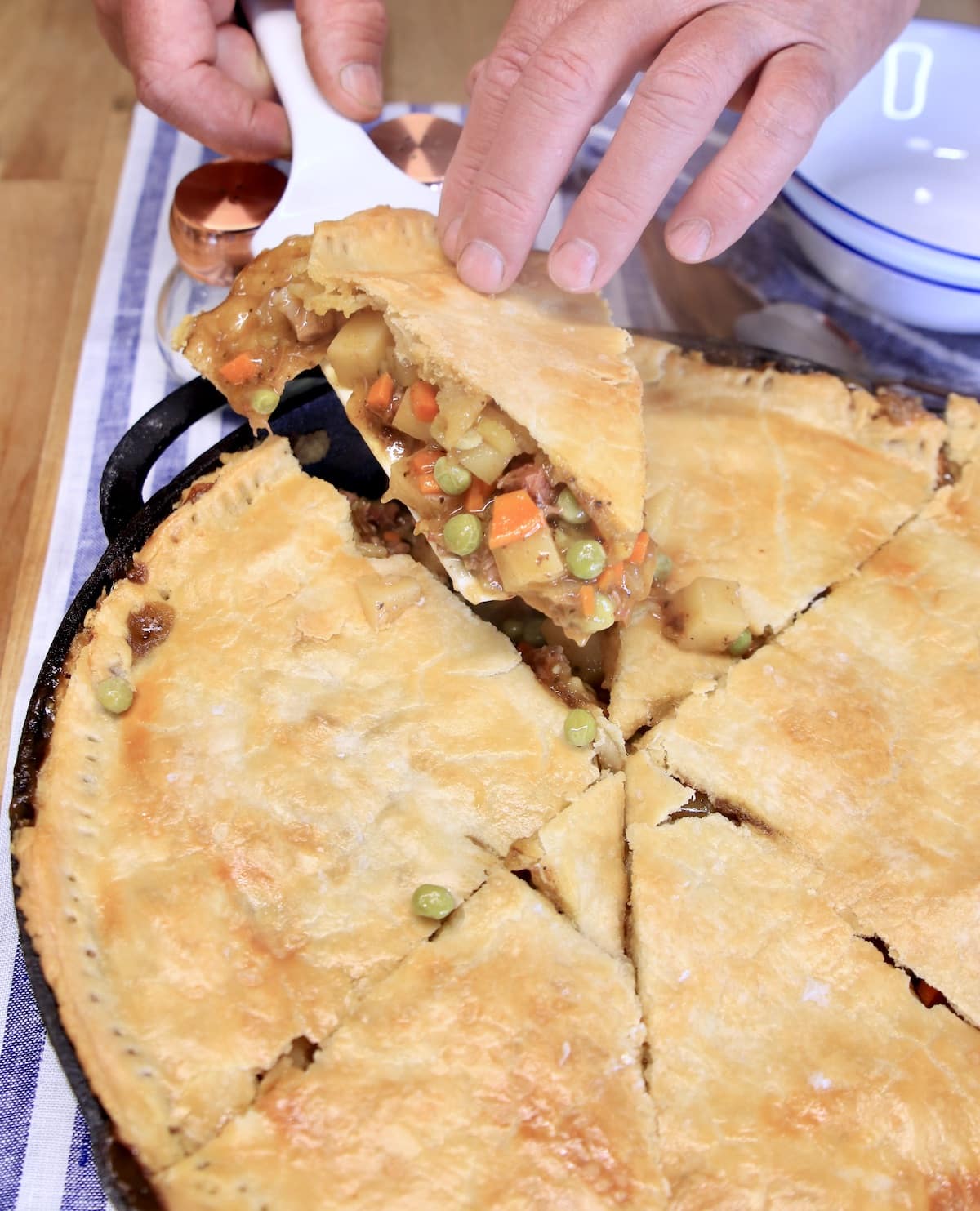 Brisket Pot Pie, removing 1 slice from skillet.