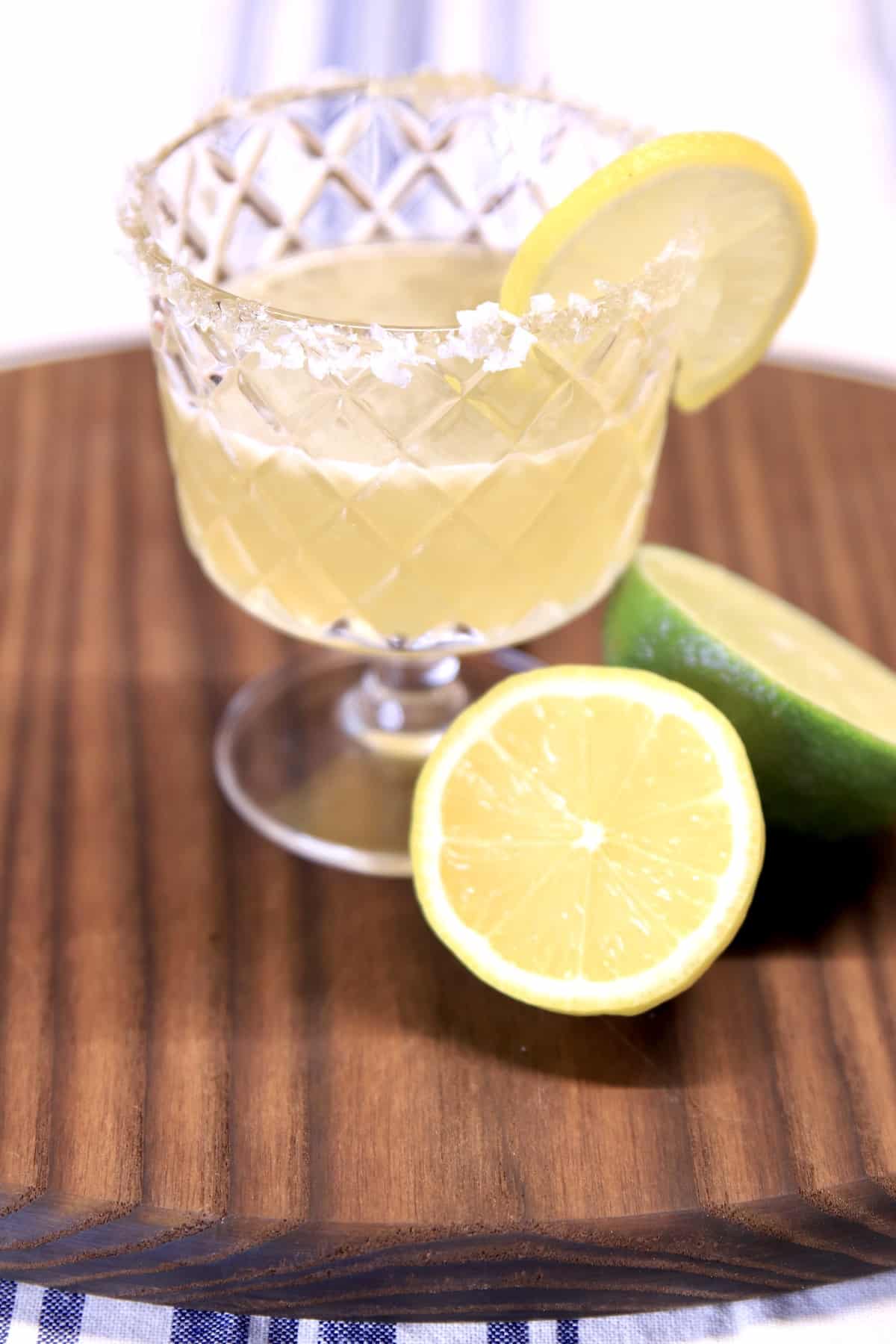 Italian Margarita with lemon garnish on a dark board.