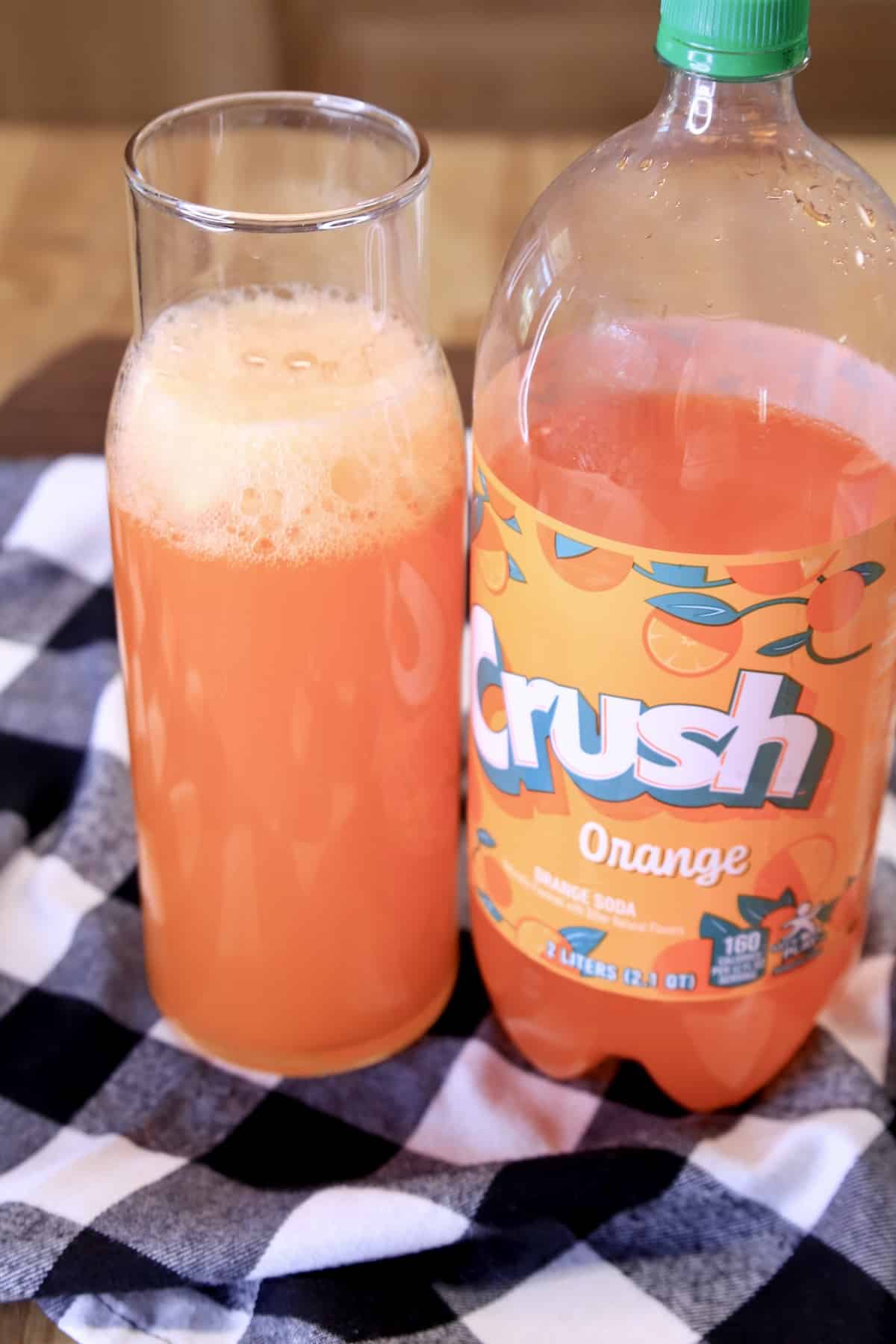Pitcher of punch with bottle of orange crush soda.