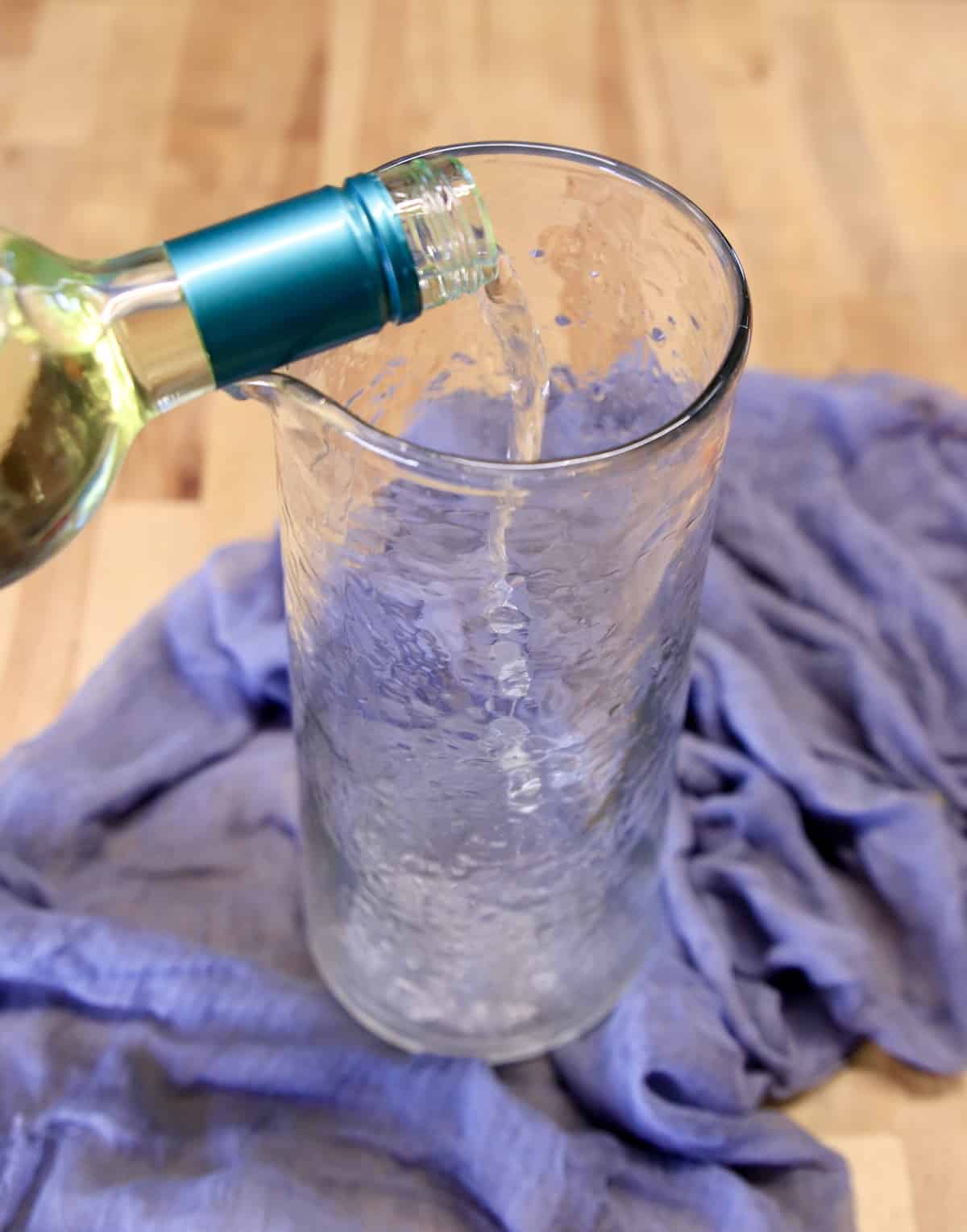Pouring wine into pitcher.