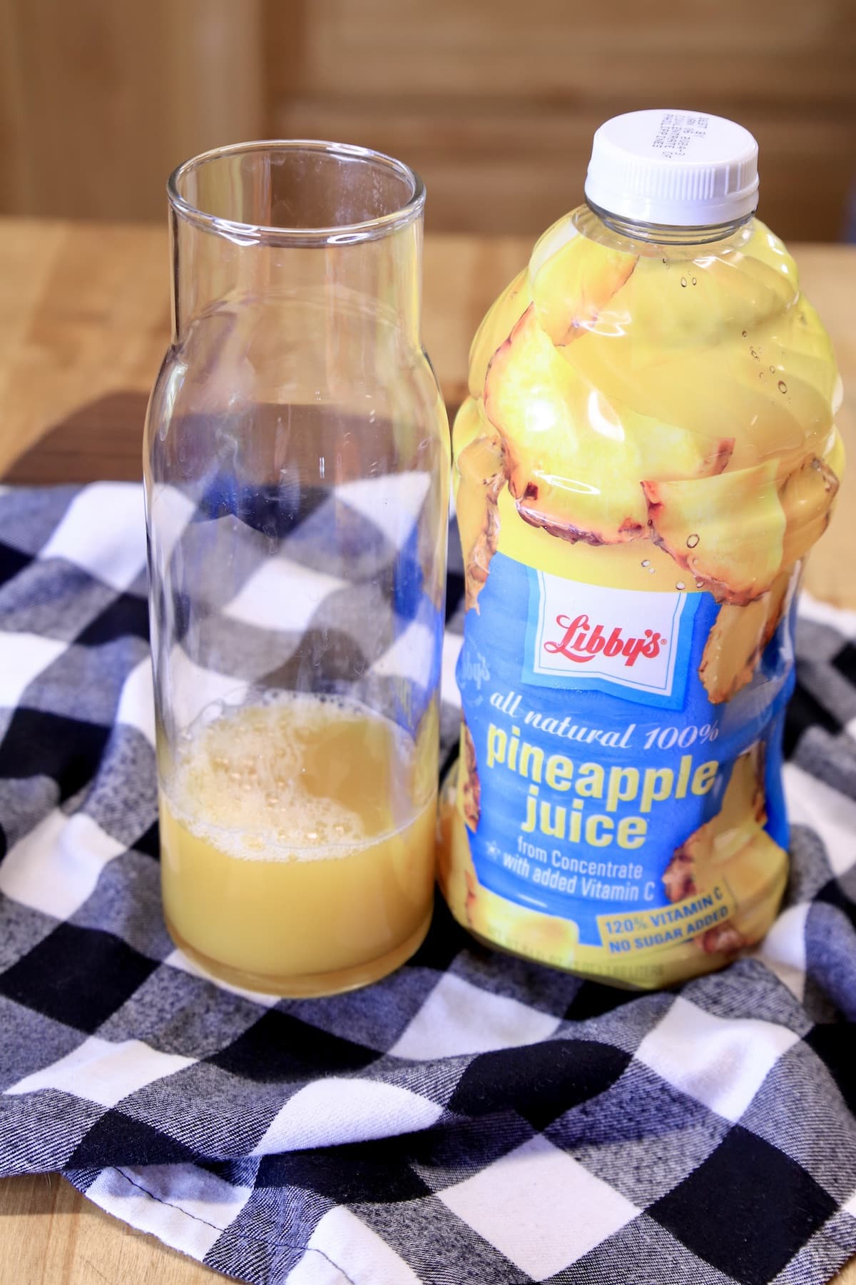 Small pitcher with pineapple juice bottle. 