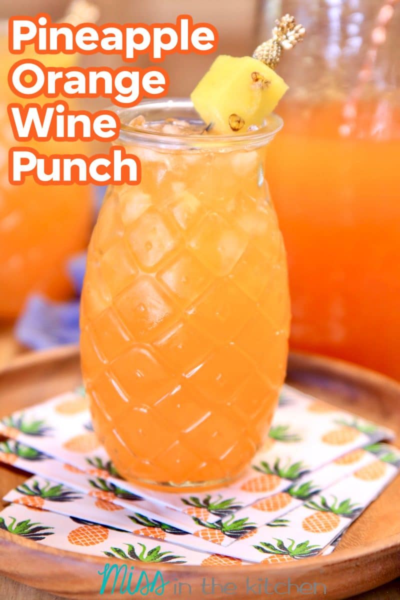 Pineapple Orange Wine Punch in pineapple glass. Text overlay.