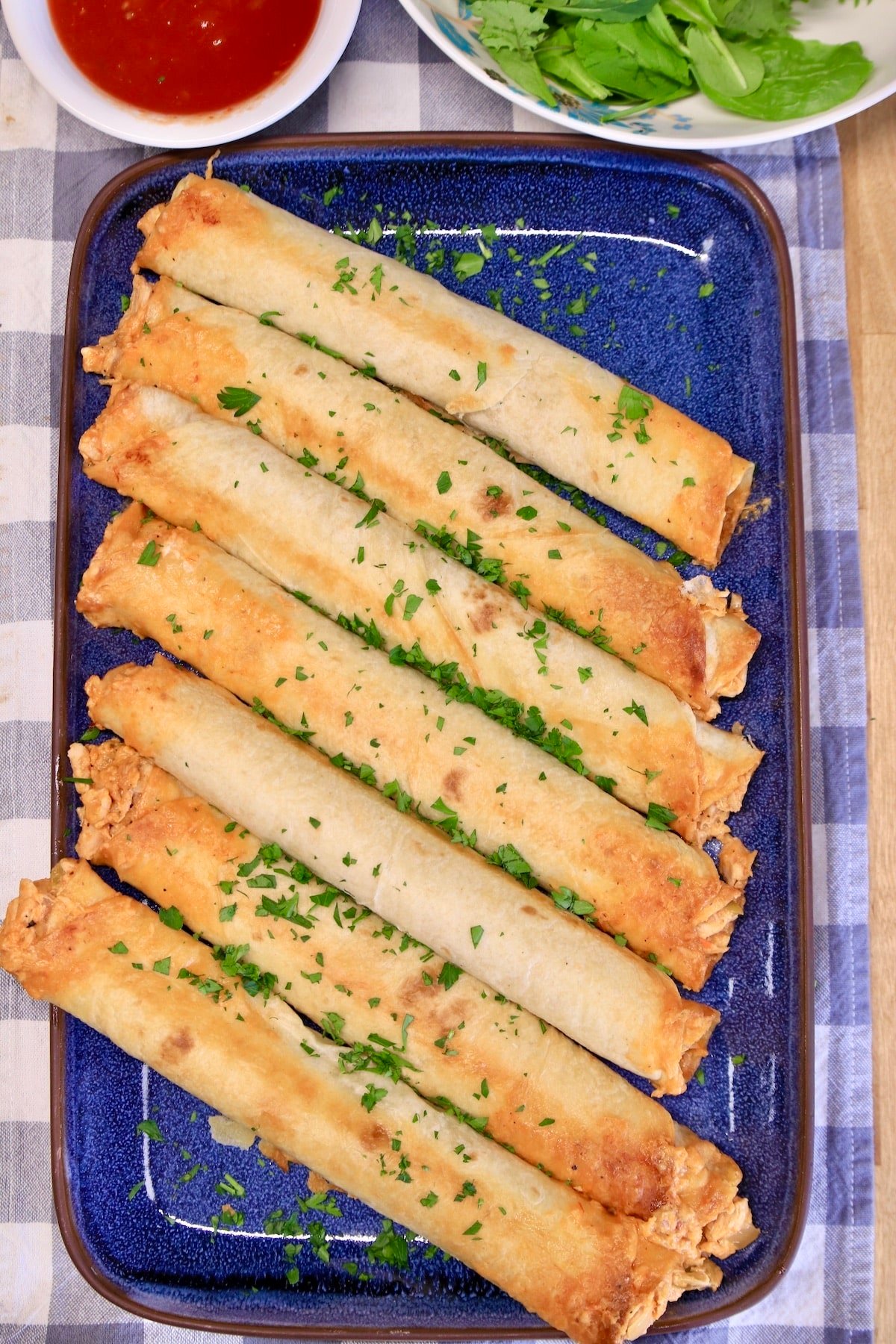 Platter of rolled chicken tacos.