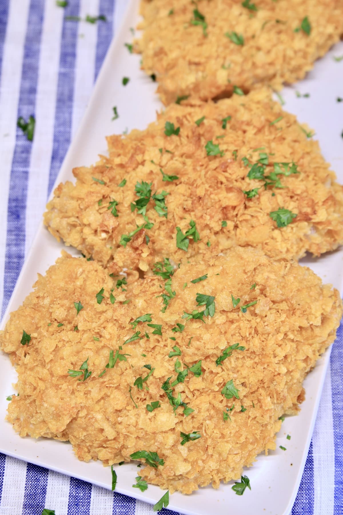 Cornflake crusted pork chops on a platter.