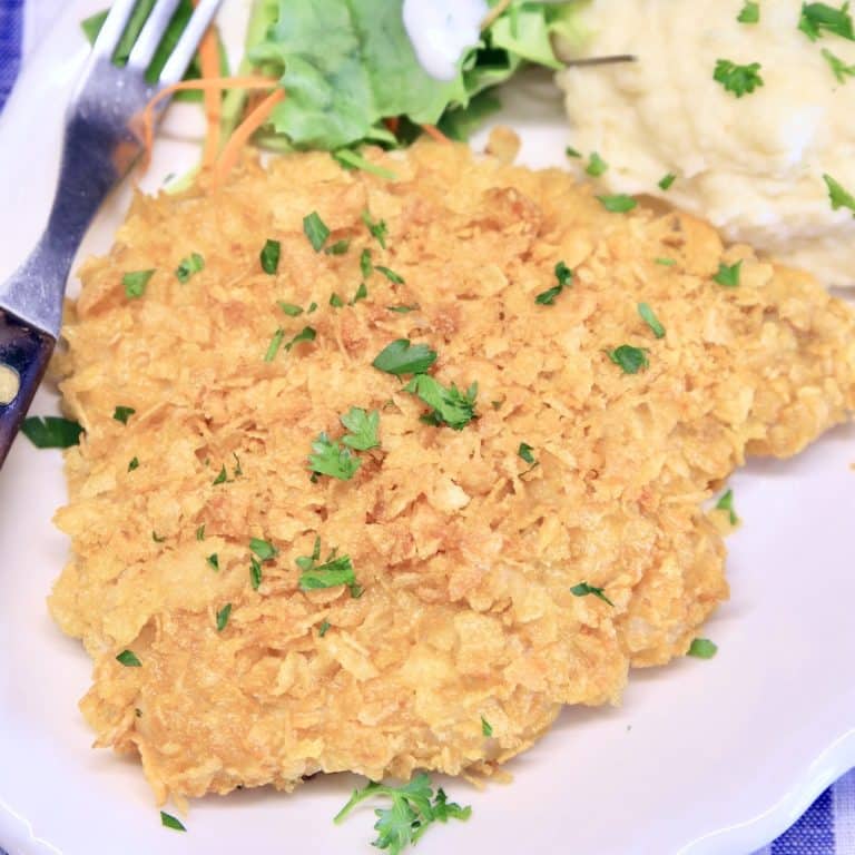 Cornflake crusted Pork Chop on a plate with mashed potatoes.