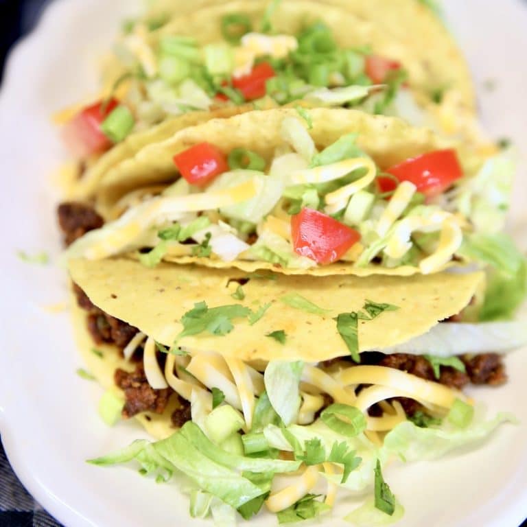 Ground beef tacos with lettuce, tomatoes, cheese.
